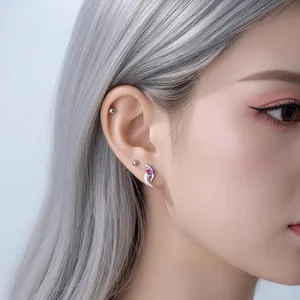 Silver angel wing heart zircon cartilage stud earring worn on a female model's ear
