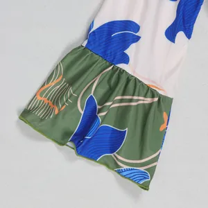 Detail shot of the ruffled bell sleeve featuring a colorful floral print on fabric