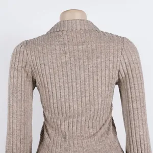 Back view detail of an elegant beige ribbed knit top with lantern sleeve texture