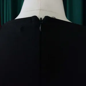 Close-up detail of back invisible zipper on a professional black office commute dress