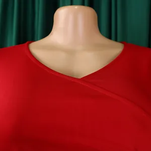 Detailed close-up of elegant red V-neckline with cross-over stitching on summer dress.