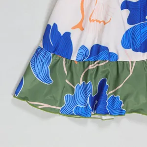 Detailed close-up showing vibrant blue floral print and ruffled hem of a short dress.