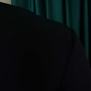 Close-up detail of the premium smooth black fabric on a woman's office dress shoulder
