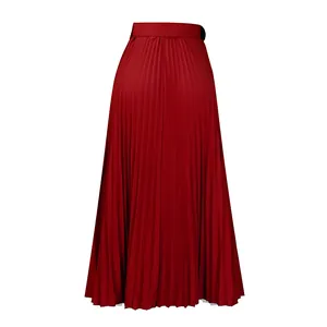 Détail d'une élégante jupe mi-longue plissée rouge à taille haute au drapé fluide.