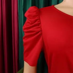 Detailed close-up of elegant puff sleeves on a vibrant red summer fashion dress.