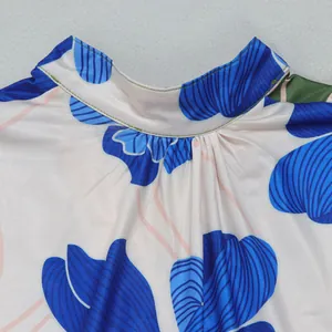 Close-up detail of gathered high neck collar on elegant blue floral print dress.