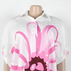Elegante witte high-low blouse met grote roze bloemenprint en klassieke reverskraag