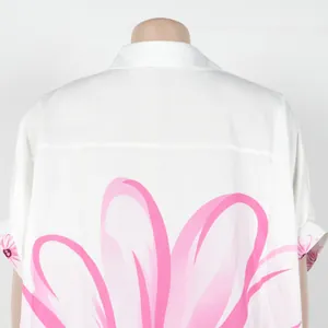Achterdetail van elegante witte blouse met bloemenprint en asymmetrische zoom.