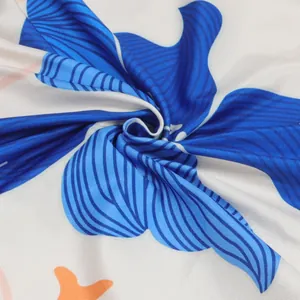 Detailed close-up of elegant blue floral print fabric showing smooth textile texture and drape