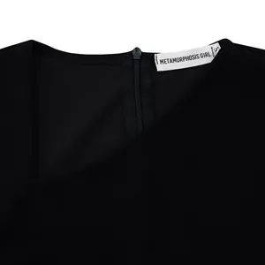 Macro detail showing the asymmetrical neckline and back zipper of a elegant black dress