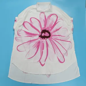 Detailweergave van een elegant oversized wit overhemd met een grote roze bloemenprint.