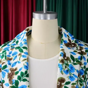 Dettaglio ravvicinato di un blazer bianco con vivaci stampe floreali blu e verdi.