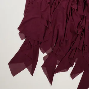 Detail view of burgundy layered mesh patchwork hem on elegant slim fit dress.