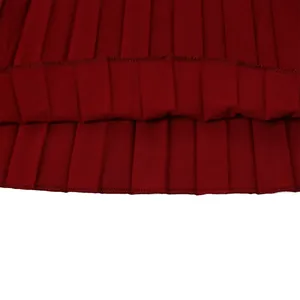 Vue détaillée de l'ourlet d'une jupe midi plissée bordeaux montrant la texture du tissu