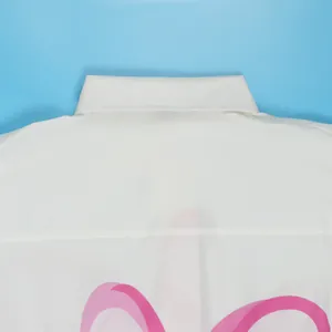 Macrodetail van een witte hemdskraag met een gestileerde roze grafische print achter