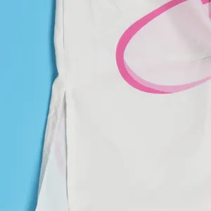 Detailopname van de zijsplit op een wit lang overhemd met roze bloemmotieven erop