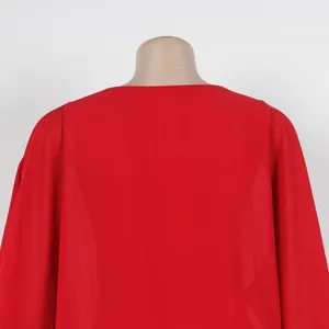 Vista posterior detallada de un vestido de capa de gasa roja suelta en un torso de maniquí