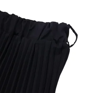 Gros plan sur la taille élastique et les plis pressés d'une jupe midi noire élégante