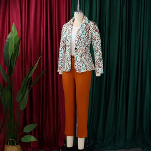 Completo elegante due pezzi con blazer stampato e pantaloni slim arancioni su manichino