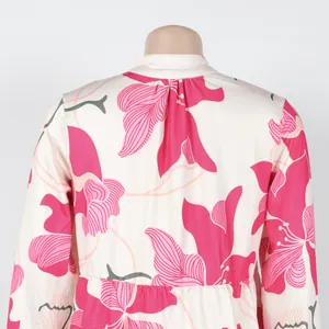 Detailed back view of a cream mini dress featuring vibrant pink lily floral prints.
