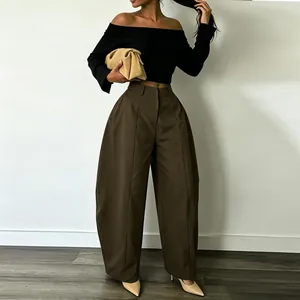 Detail of high-waisted coffee brown wide-leg trousers in a loose silhouette