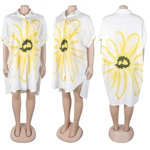 Detail van wit shirt met revers, gele zonnebloemprint en een modieuze high-low zoom