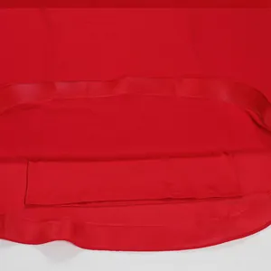 Primer plano del dobladillo de un vestido de gasa roja con detalle de cinta elegante