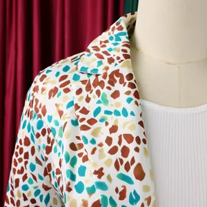 Dettaglio ravvicinato di un blazer bianco con una vivace stampa a pois colorata