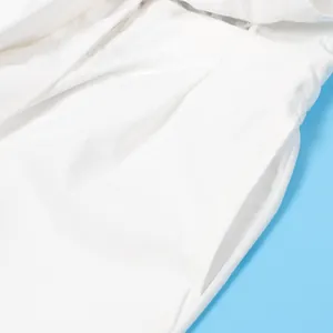 Makro-Detailaufnahme von Tasche und Nähten eines weißen, lässigen Jumpsuits mit V-Ausschnitt