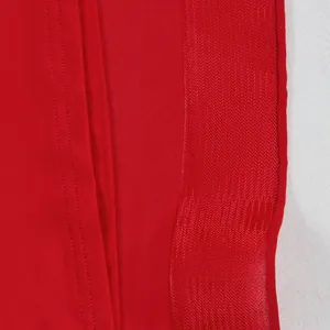 Vista macro detallada que muestra la tela de gasa roja de calidad y las costuras de precisión.