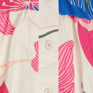 Detail showing button closure and vibrant floral print on elegant patchwork dress