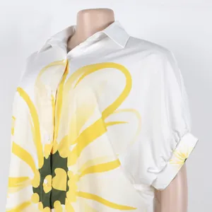 Detail van wit overhemd met knopen en grote gele zonnebloemprint