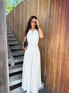 Model wearing elegant white halter V-neck draped top and wide-leg pants set