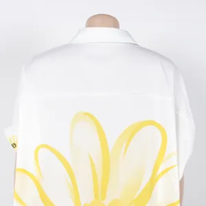 Achteraanzicht van wit shirt met lange mouwen en grote gele zonnebloem print detail