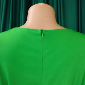 High-quality detail view of a green fashion dress showing a hidden back zipper on a mannequin.