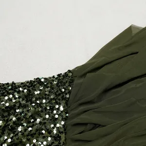 Close-up view of elegant olive green dress featuring shiny sequins and mesh fabric texture.
