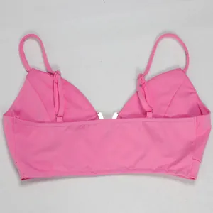 Λεπτομερής πίσω όψη ενός ζωντανού ροζ τοπ bralette από ένα κομψό σετ κοστουμιών τριών τεμαχίων