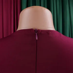 Detailansicht des versteckten Rückenreißverschlusses an einem burgunderroten Kleid.