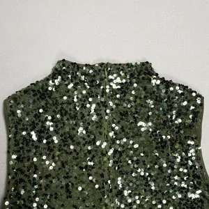 Close-up of green sequined dress showing back invisible zipper and mock neck detail.