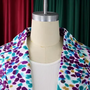 Dettaglio ravvicinato di un blazer da donna con stampa astratta colorata e risvolto a punta chic