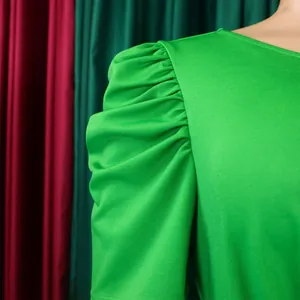 Macro detail view of vibrant green pleated puff sleeve on an elegant summer dress