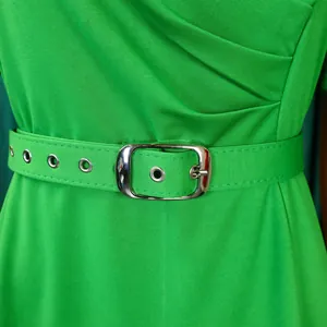 Detailed view of vibrant green pleated dress waist featuring matching belt with buckle