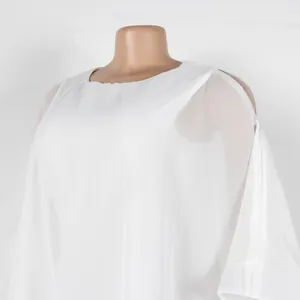Detalle de la gasa blanca y el elegante diseño de hombros descubiertos del vestido
