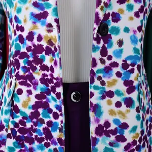 Primo piano di un blazer a fiori con bottoni neri e pantaloni viola coordinati.