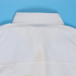 Gedetailleerde macroweergave van de elegante witte overhemdkraag met fijne stiksels
