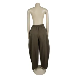 Detailed back view of brown loose wide-leg commuter trousers on a mannequin stand