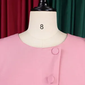 Close-up detail of a pink elegant round neck dress featuring decorative buttons