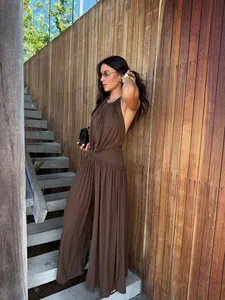 Elegant brown halter neck pleated wide leg jumpsuit set shown on model in outdoor setting