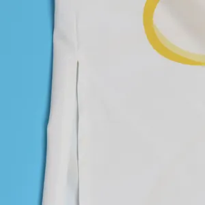 Detailopname van een witte elegante lange blouse met zijsplit en gele printopdruk