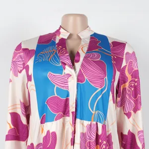 Detailed view of elegant floral print V-neck dress with color blocking on a mannequin.